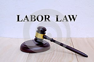 Labor Law written on the wall with gavel on wooden background. Law concept