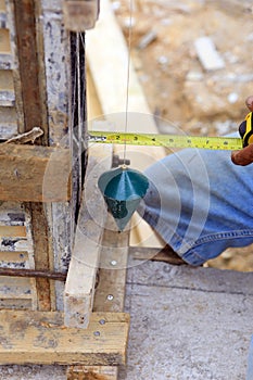 Labor man using a plumb bob for check