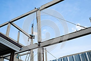 labor man working high concrete pile no safety . Worker risk on top structure home building site. white small cloud on blue sky