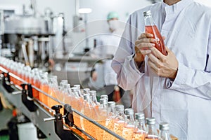 Labor worker working in drink factory production line fruit juice beverage product at conveyor belt