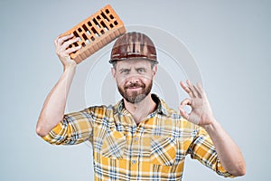 labor or workers day. man laborer with brick. guy wear worker uniform. handsome builder in helmet