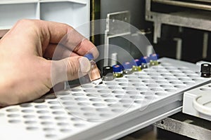 Laborant takes small bottle in laboratory