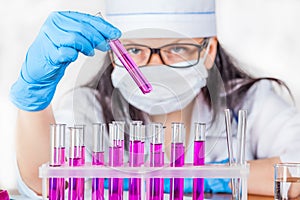 Laboratorian inspects the contents of the test tubes closeup