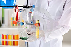 Laboratory assistant adjusting stand with test tubes, closeup