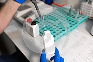 Laboratory assistant analyzing a blood sample using micropipette