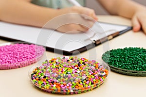 Laboratory assistant checks the quality of plastic pellets for i