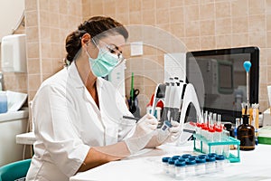 Laboratory assistant holds test tubes for gynecological and cytological analysis. Woman scientist working in medical lab photo
