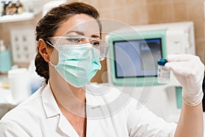 Laboratory assistant holds test tubes for gynecological and cytological analysis. Woman scientist working in medical lab