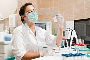 Laboratory assistant holds test tubes for gynecological and cytological analysis. Woman scientist working in medical lab