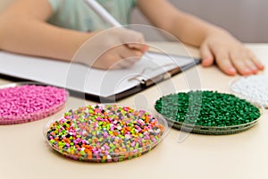 Laboratory assistant inspections plastic pellets for industry. Plastic raw materials in granules . Polymer, plastic resin.