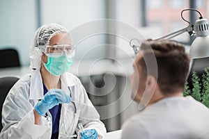 A laboratory assistant in a private clinic takes a swab from the patient's nasopharynx, a PCR test for coronavirus covid