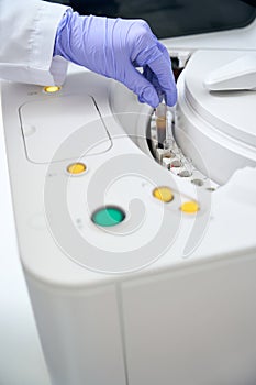 Laboratory assistant removes a test tube with a biomaterial sample