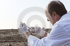 Laboratory assistant tacking samples of soil in the field to testing them