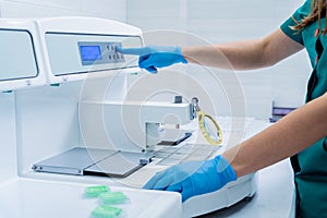 Laboratory assistant works at paraffin wax dispenser tissue embedding machine.