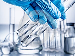 Laboratory beakers in analyst`s hand.