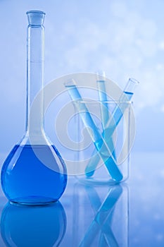 Laboratory beakers, microscope, blue background