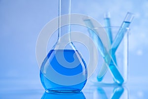 Laboratory beakers, microscope, blue background