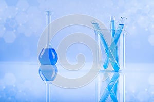 Laboratory beakers, microscope, blue background