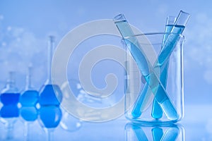 Laboratory beakers, microscope, blue background