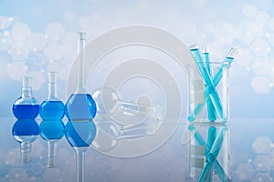 Laboratory beakers, microscope, blue background