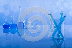 Laboratory beakers, microscope, blue background