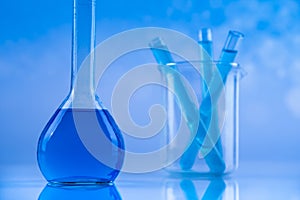 Laboratory beakers, microscope, blue background