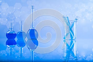 Laboratory beakers, microscope, blue background