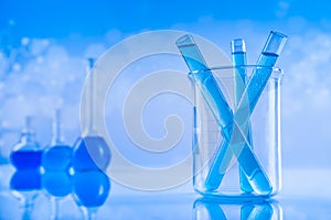 Laboratory beakers, microscope, blue background