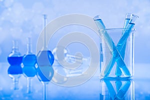 Laboratory beakers, microscope, blue background