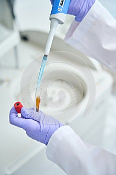 Laboratory employee prepares a biomaterial for loading into biochemical analyzer