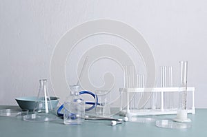 Laboratory equipmant for medical research.Glassware on the blue lab table against white wall.Empty space for text