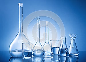 Laboratory equipment, bottles, flasks on blue background