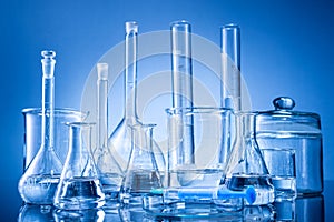 Laboratory equipment, bottles, flasks on blue background photo