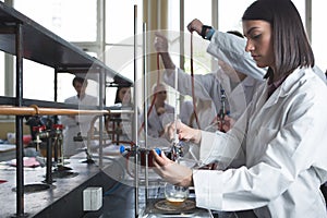 Laboratory equipment for distillation.Student/intern/technician's hands showing experiment.Working in teams for a better result.Sc