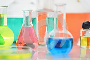 Laboratory flasks and beakers with liquids of different colors on lab table