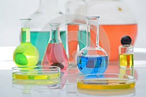 Laboratory flasks and beakers with liquids of different colors on lab table