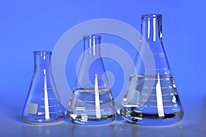 Laboratory Flasks Over Blue Background