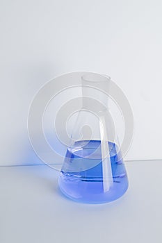 Laboratory glass Erlenmeyer conical flask filled with blue chemical liquid for a chemistry experiment in a science