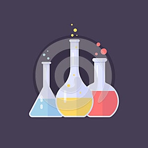 Laboratory glass flasks and test tubes with blue, yellow and pink liquid. Chemical and biological experiments.