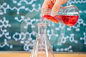 Laboratory glassware with blackboard background with various chemical formulas