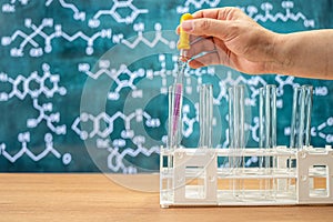 Laboratory glassware with blackboard background with various chemical formulas