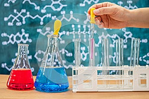 Laboratory glassware with blackboard background with various chemical formulas