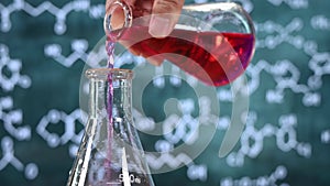 Laboratory glassware with blackboard background with various chemical formulas