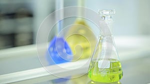 Laboratory glassware with color liquid and with reflection. test tubes and flasks with green and blue liquid in a