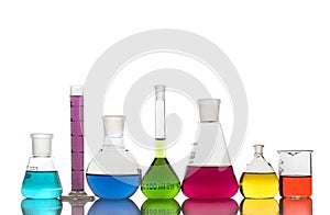 Laboratory glassware with colorful liquids on white background