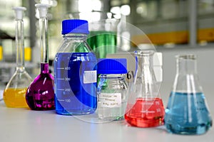 Laboratory glassware containing colorful chemical liquid, lab research and development concept