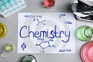 Laboratory glassware and paper with word CHEMISTRY