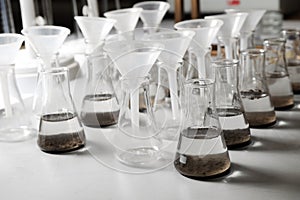 Laboratory glassware with soil extracts and funnels photo