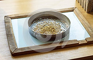 Laboratory for the inspection and analysis of grain, on the table lies a sieve and grain, granule