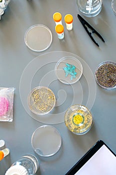 Laboratory instrument set and glitter samples in petri dishes over a lab table background photo